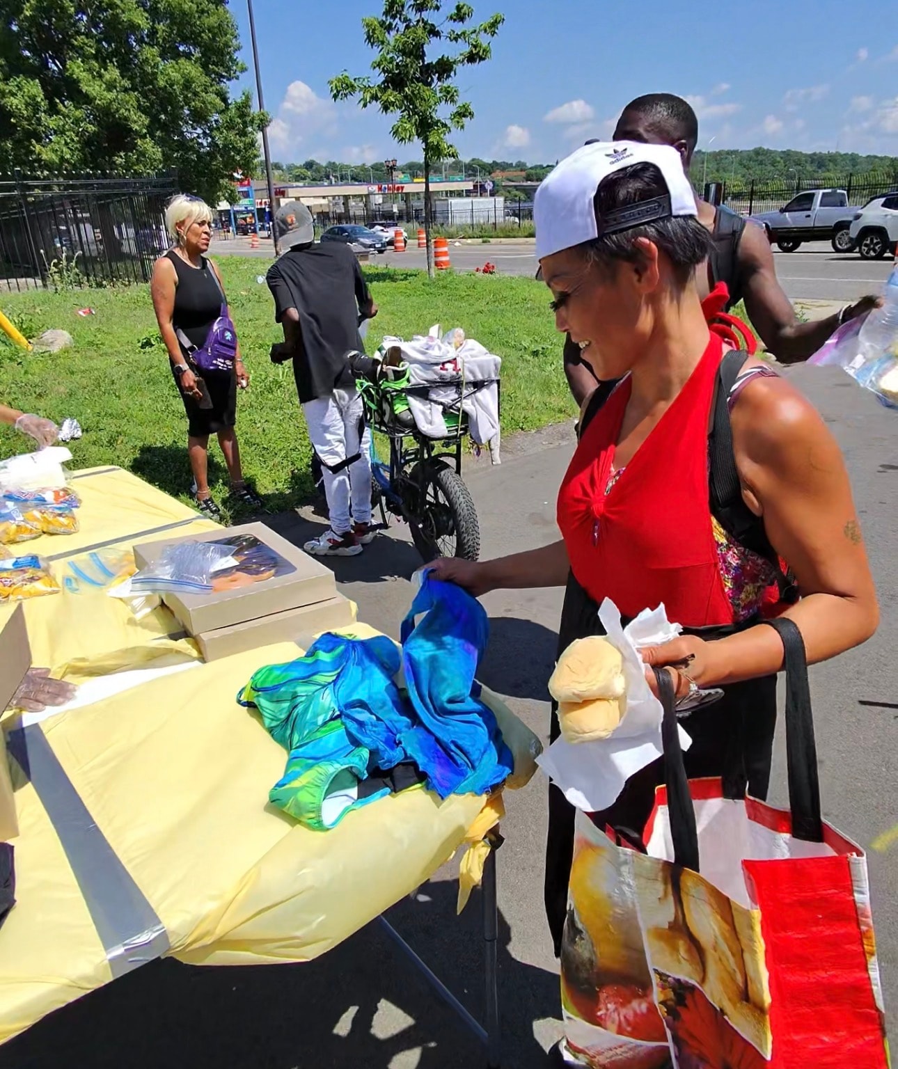 Community member selecting clothing and food at an outdoor outreach table