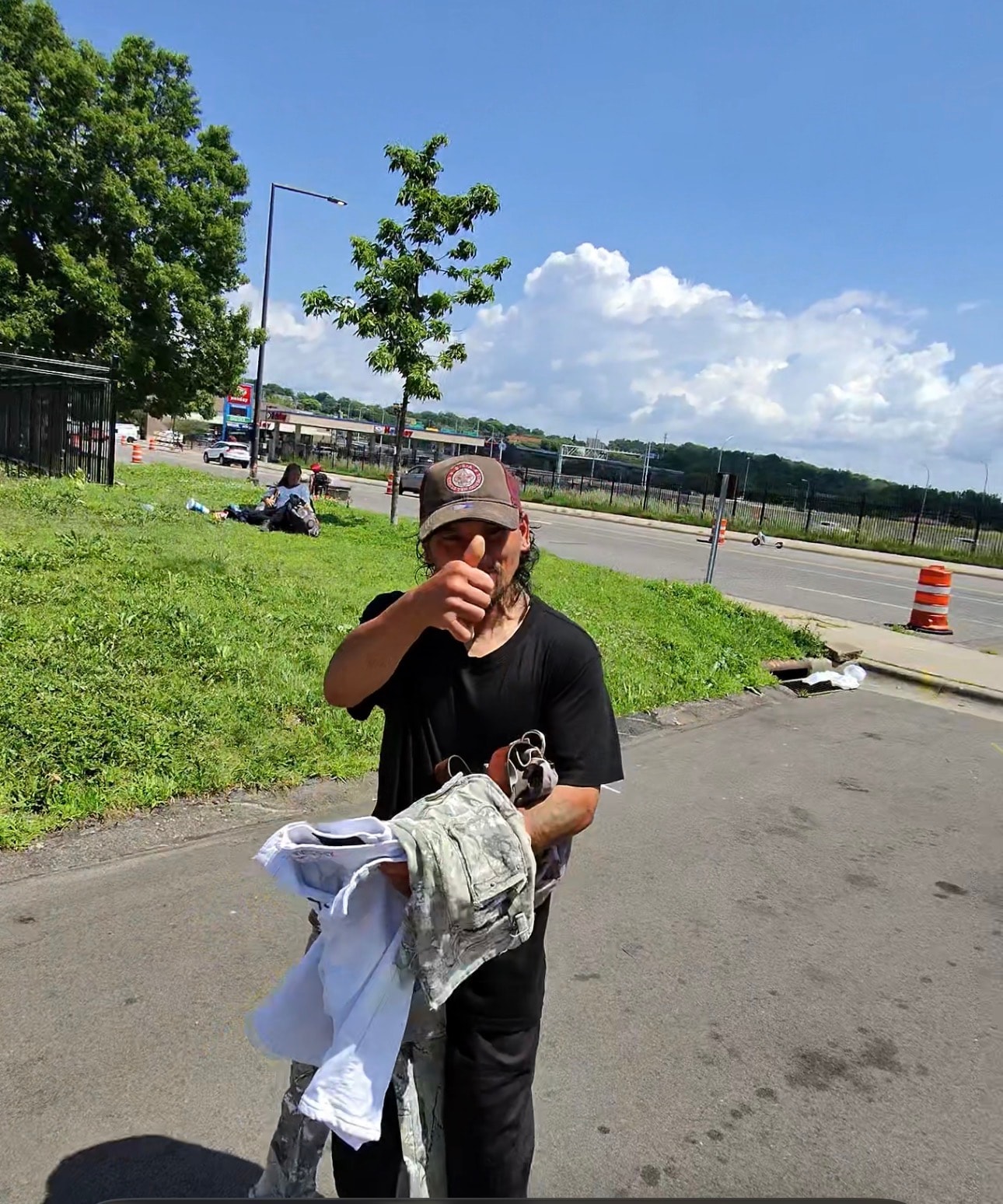 Community member giving a thumbs up after receiving clothing at an outreach event