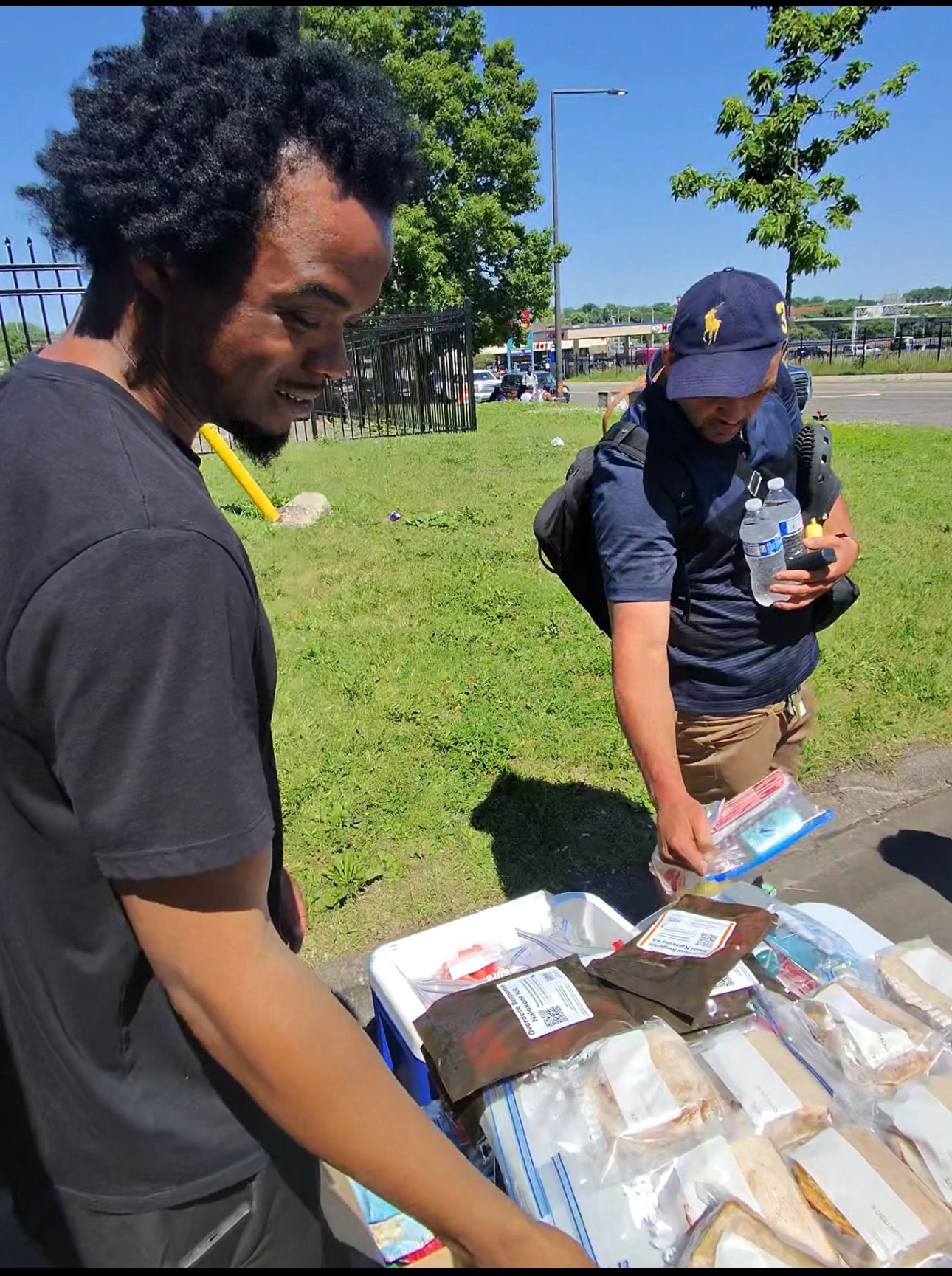 Community member smiling while receiving food and supplies at a Threshold to Thrive outreach event